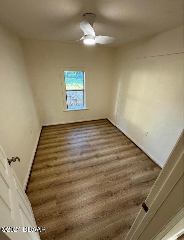 empty room with ceiling fan and wood finished floors