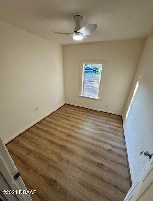 spare room featuring ceiling fan, wood finished floors, and baseboards