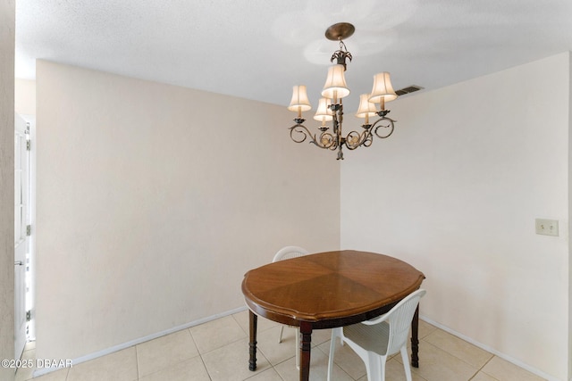 dining area featuring light tile patterned floors, baseboards, and a notable chandelier