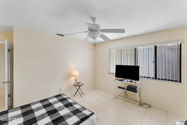 interior space with tile patterned floors, visible vents, a textured ceiling, and ceiling fan