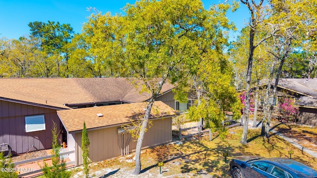 exterior space with roof with shingles and fence