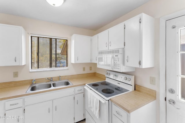 kitchen with a sink, white appliances, white cabinets, and light countertops