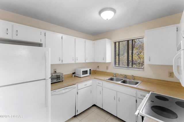 kitchen with white appliances, light tile patterned floors, a sink, light countertops, and white cabinetry