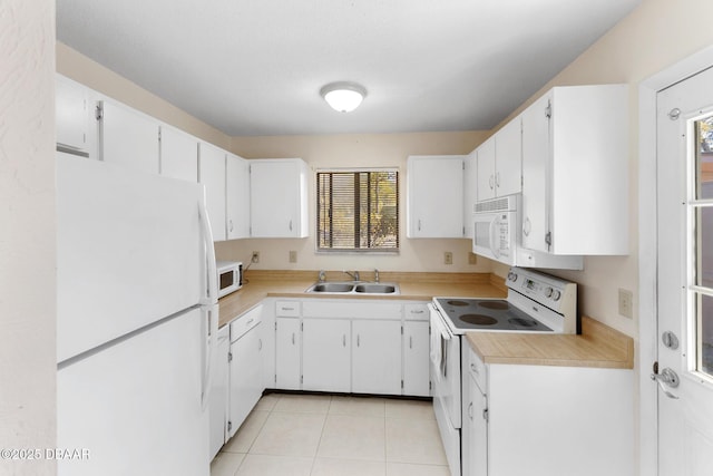 kitchen with white appliances, light tile patterned floors, a sink, light countertops, and white cabinetry