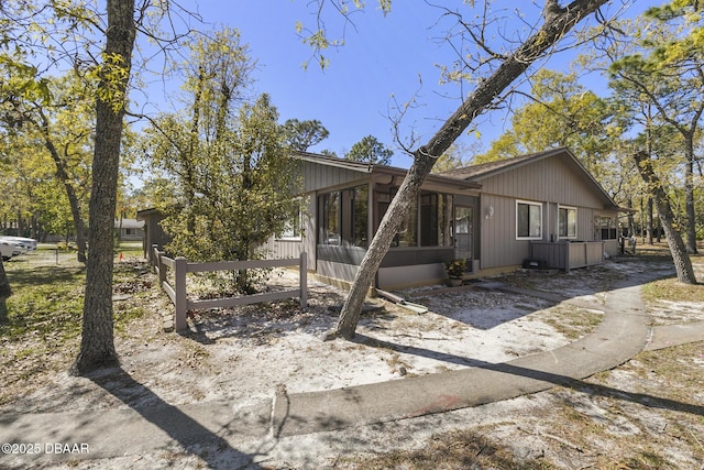 view of front of home featuring fence and a sunroom