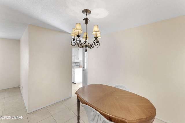 dining space with a textured ceiling, an inviting chandelier, and light tile patterned flooring