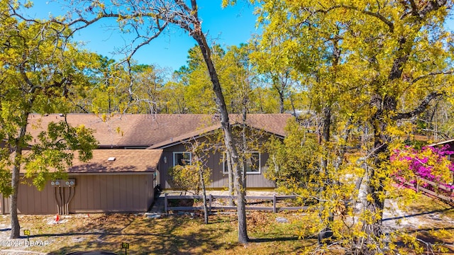 exterior space featuring a shingled roof and fence