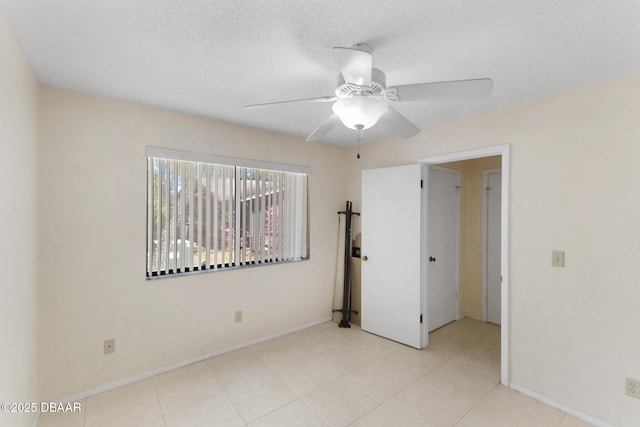 unfurnished bedroom featuring baseboards, a textured ceiling, and a ceiling fan