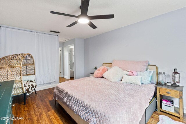 bedroom with dark hardwood / wood-style flooring and ceiling fan