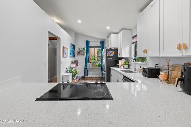 kitchen featuring white cabinetry, stainless steel dishwasher, sink, and black electric cooktop