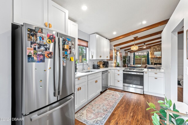 kitchen featuring white cabinets, lofted ceiling with beams, stainless steel appliances, and sink