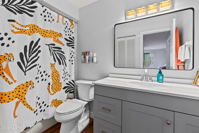 bathroom featuring hardwood / wood-style floors, vanity, toilet, and a shower with curtain