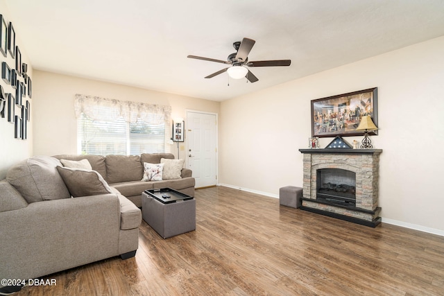 living room featuring a fireplace, wood-type flooring, and ceiling fan