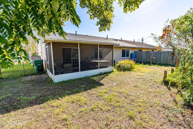 back of property featuring a sunroom and a yard