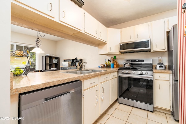 kitchen featuring white cabinets, decorative light fixtures, sink, and appliances with stainless steel finishes