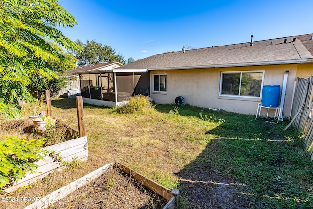 back of property featuring a lawn and a sunroom