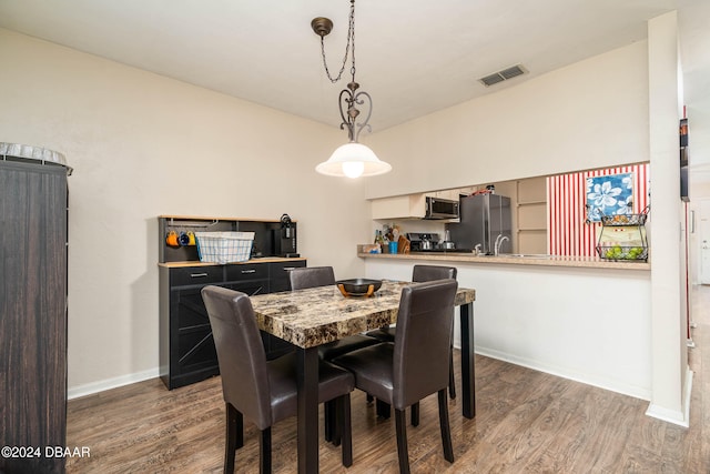 dining room featuring dark wood-type flooring and sink