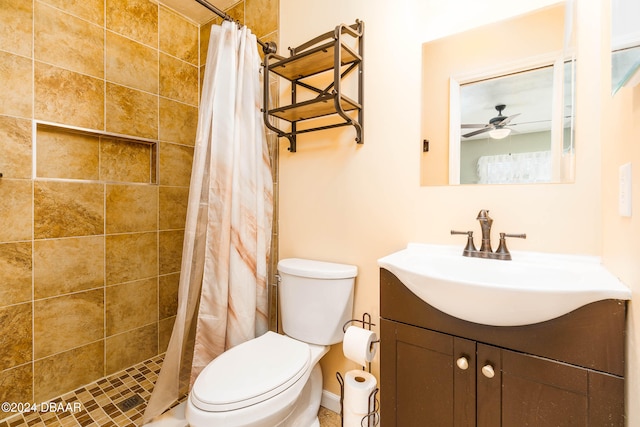 bathroom featuring a shower with curtain, ceiling fan, vanity, and toilet