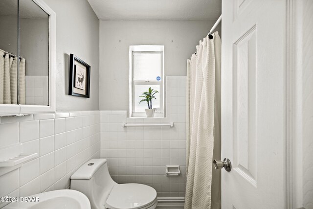 bathroom with toilet and tile walls