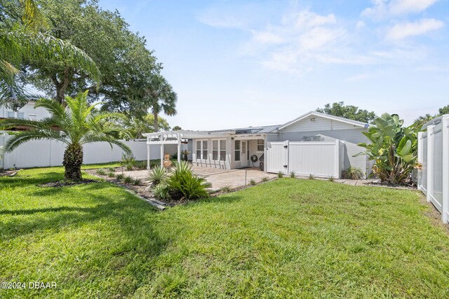 back of property featuring a yard, a patio, and a pergola