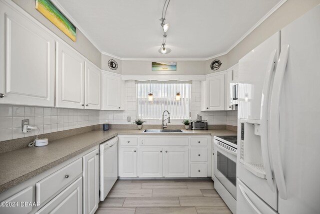 kitchen with white appliances, white cabinetry, and sink