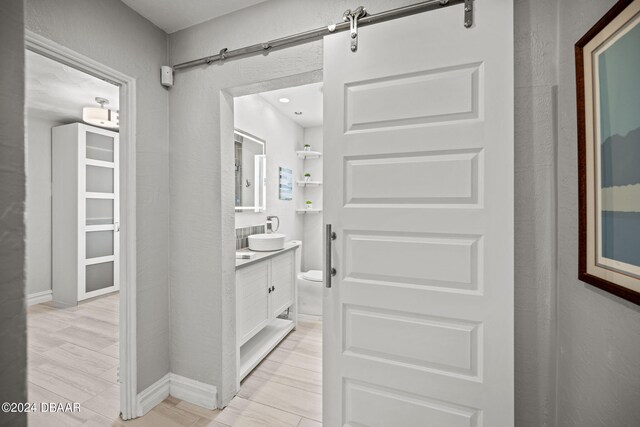 bathroom with hardwood / wood-style flooring, vanity, and toilet