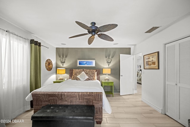 bedroom featuring light hardwood / wood-style floors, ceiling fan, and a closet