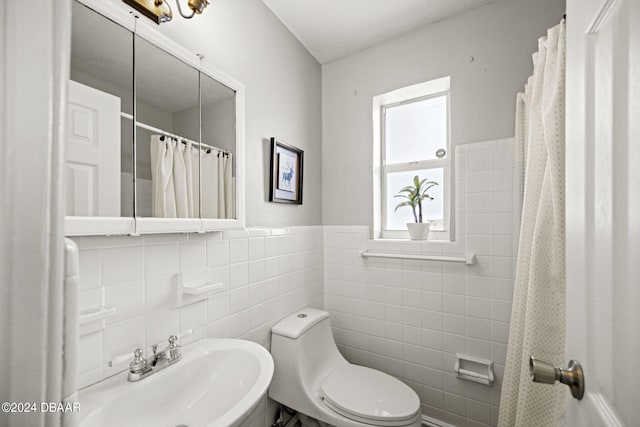 bathroom with tile walls, sink, and toilet