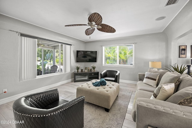 living room featuring light wood-type flooring, a wealth of natural light, and ceiling fan