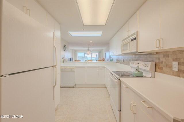 4 Oceans W Blvd Unit 407B, Daytona Beach Shores, FL 32118 - kitchen featuring white appliances, tasteful backsplash, a sink, light countertops, and light tile patterned floors