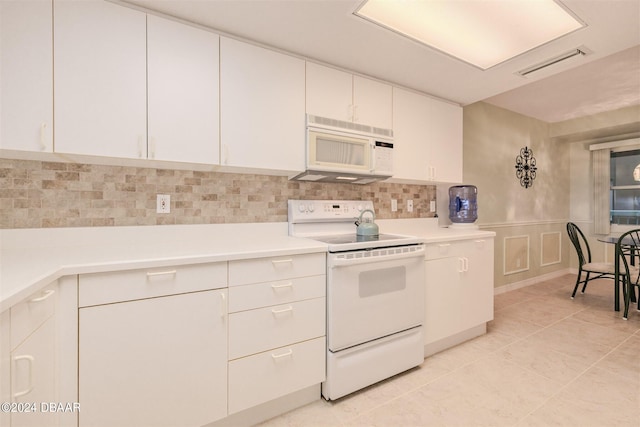 4 Oceans W Blvd Unit 407B, Daytona Beach Shores, FL 32118 - kitchen with white appliances, light countertops, decorative backsplash, white cabinets, and a decorative wall