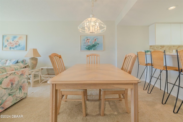 carpeted dining space featuring an inviting chandelier