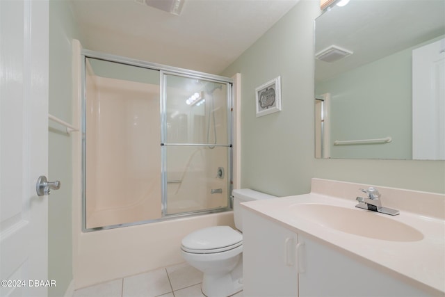 full bathroom featuring toilet, vanity, tile patterned flooring, and enclosed tub / shower combo