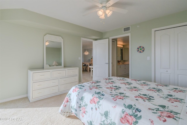 bedroom featuring ensuite bath, ceiling fan, light carpet, and a closet