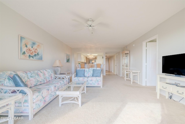 living room with ceiling fan with notable chandelier and light carpet