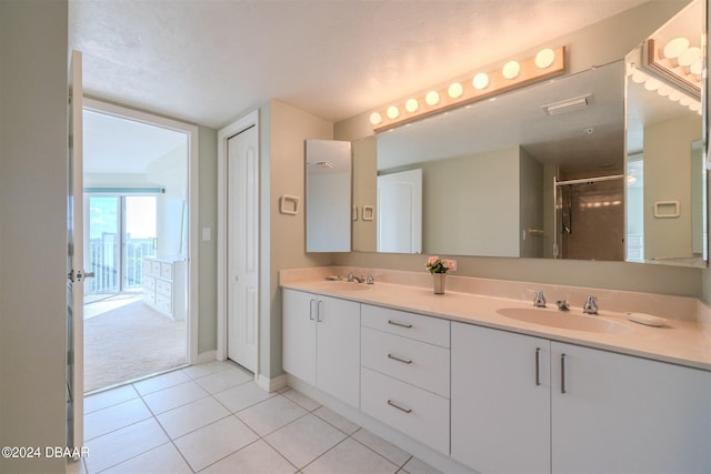 4 Oceans W Blvd Unit 407B, Daytona Beach Shores, FL 32118 - bathroom with a shower stall, tile patterned flooring, double vanity, and baseboards