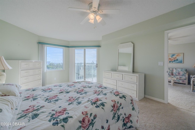 bedroom featuring access to outside, a textured ceiling, light carpet, and ceiling fan