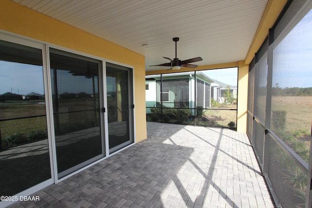 unfurnished sunroom featuring ceiling fan