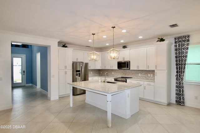 kitchen featuring light stone countertops, pendant lighting, stainless steel appliances, an island with sink, and sink