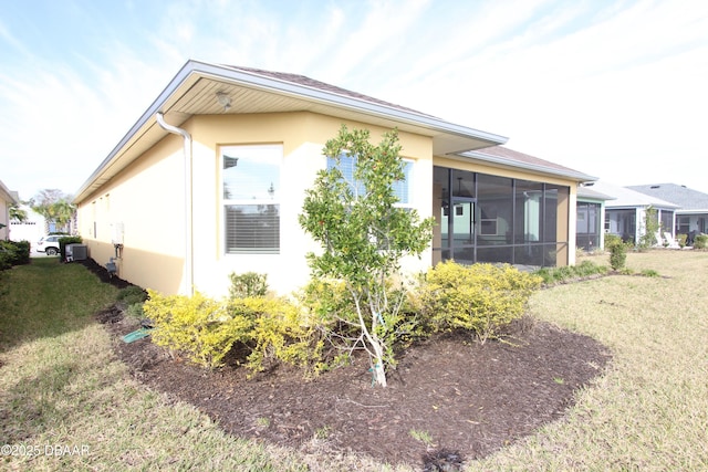 view of property exterior with a sunroom and a lawn