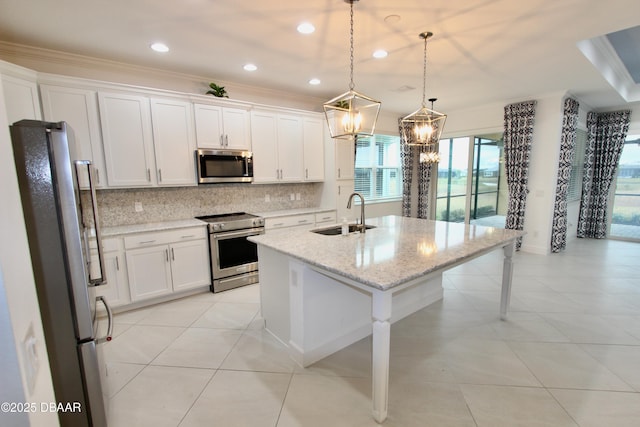 kitchen featuring white cabinetry, a center island with sink, stainless steel appliances, pendant lighting, and sink