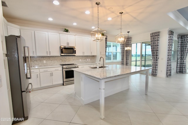 kitchen with white cabinets, appliances with stainless steel finishes, decorative light fixtures, a breakfast bar, and a center island with sink