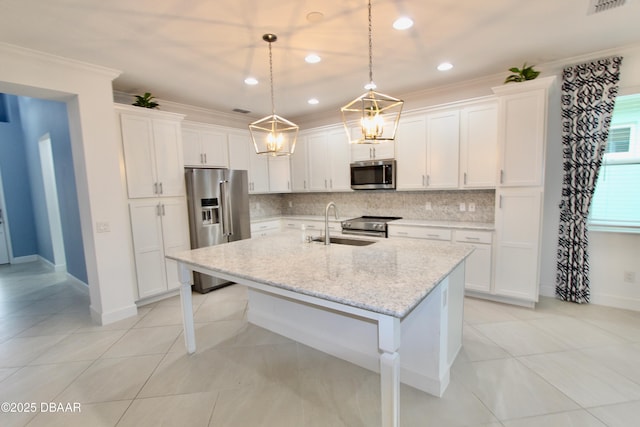 kitchen with white cabinetry, pendant lighting, appliances with stainless steel finishes, and an island with sink