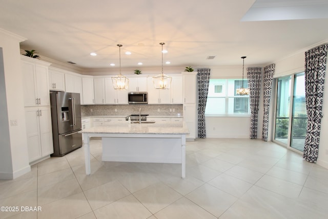 kitchen featuring light stone countertops, pendant lighting, appliances with stainless steel finishes, sink, and a center island with sink