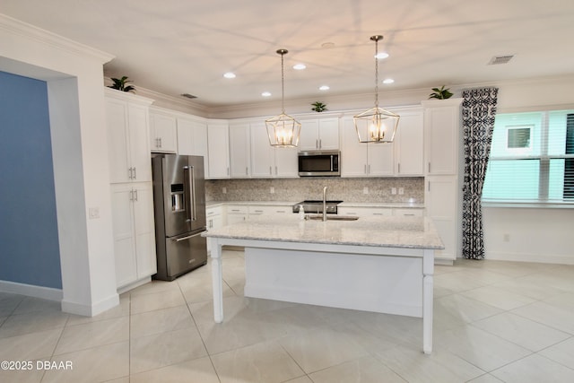 kitchen with sink, pendant lighting, appliances with stainless steel finishes, and a kitchen island with sink