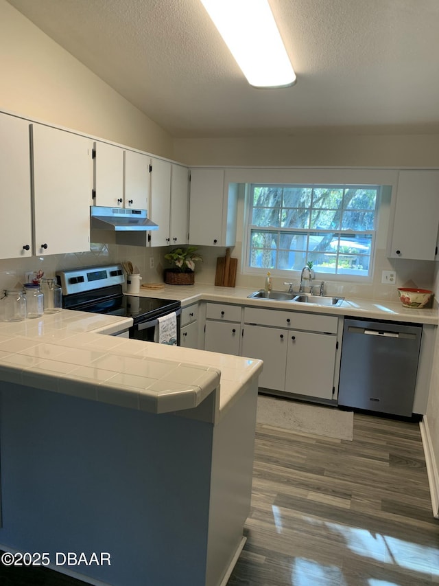 kitchen with white cabinetry, appliances with stainless steel finishes, kitchen peninsula, and sink