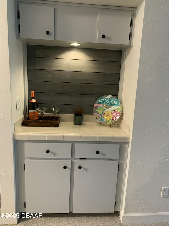 interior space featuring wooden walls and tile counters