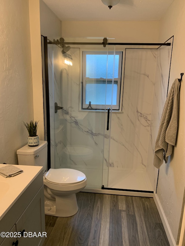 bathroom with vanity, toilet, hardwood / wood-style floors, and a shower with shower door