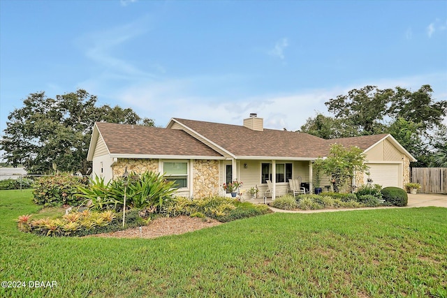 ranch-style home featuring covered porch, a garage, and a front lawn