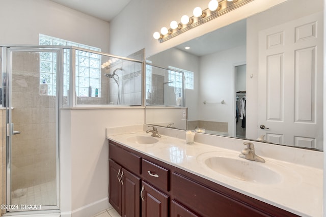 bathroom with walk in shower, tile patterned flooring, and vanity